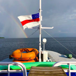 Bow of the boat and a rainbow in the distance