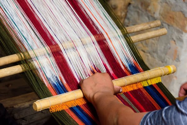 Andean Weaver with Loom multi colored fabrics